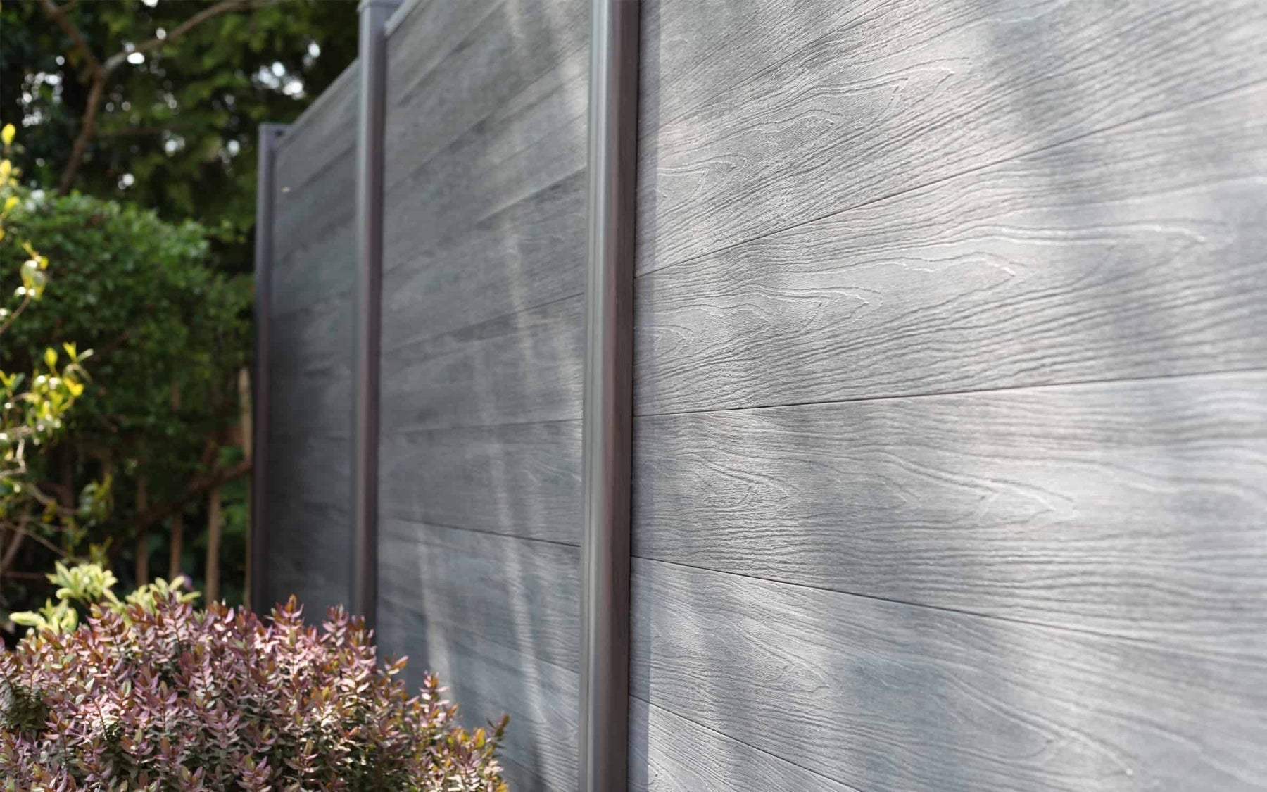 NeoTimber composite grey decking next to flower bed.