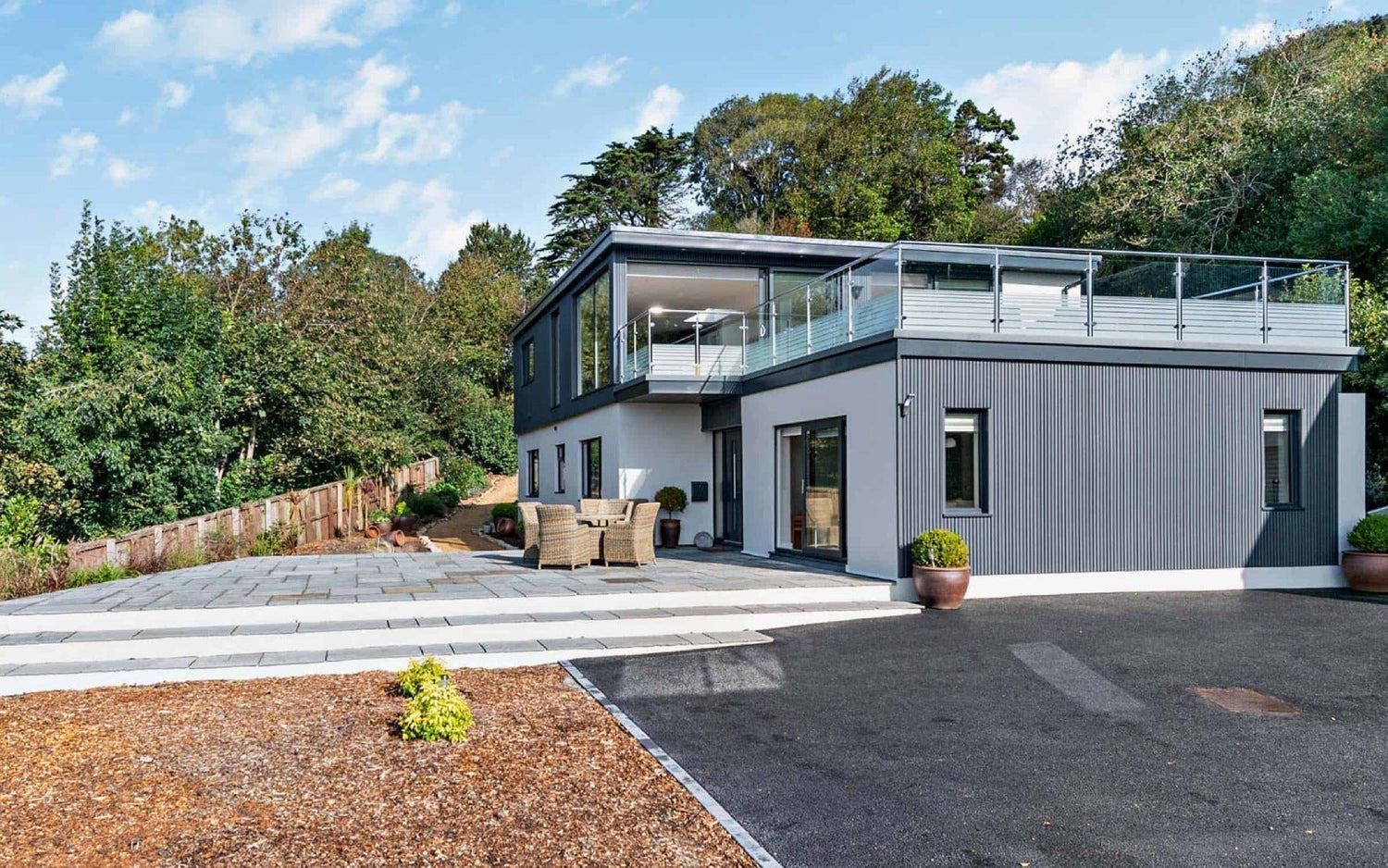 Grey slatted cladding fitted vertically to a luxury home.