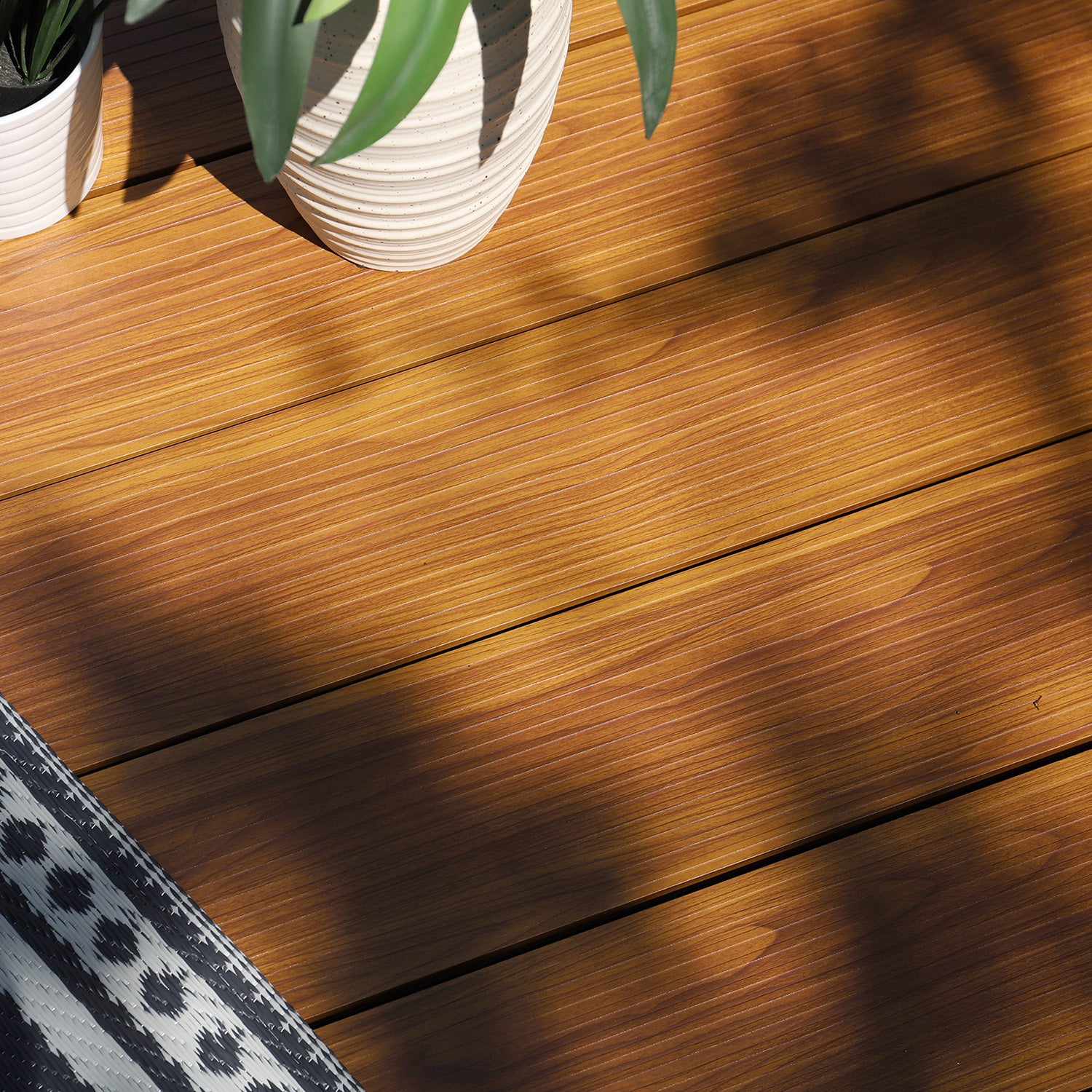 neotimber aluminium wood-effect deck with potted plants and a rug
