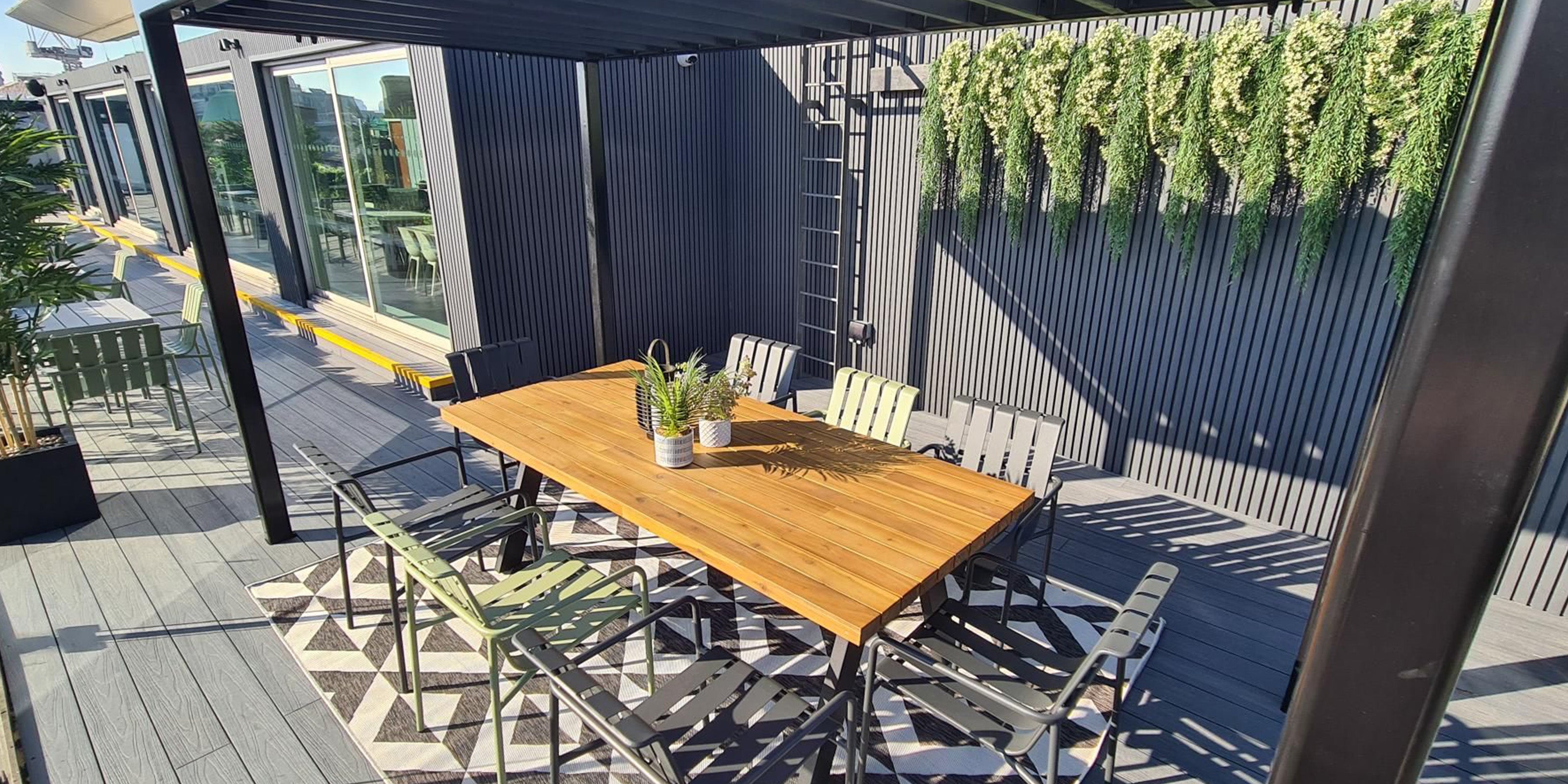 composite decking and cladding installed onto a staff office outdoor terrace with plants in the background
