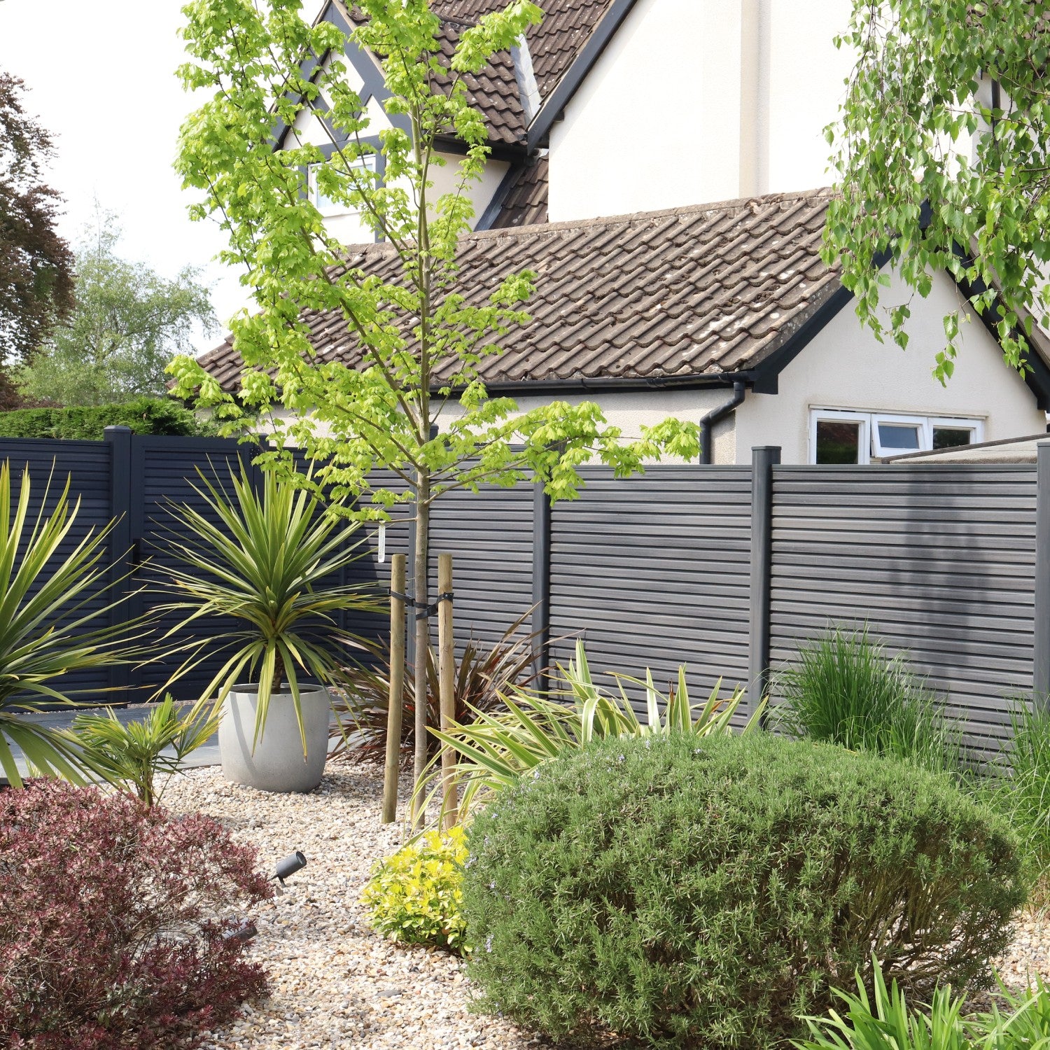 NeoTimber Slatted Fence Panel Set - Grey fitted into a modern garden